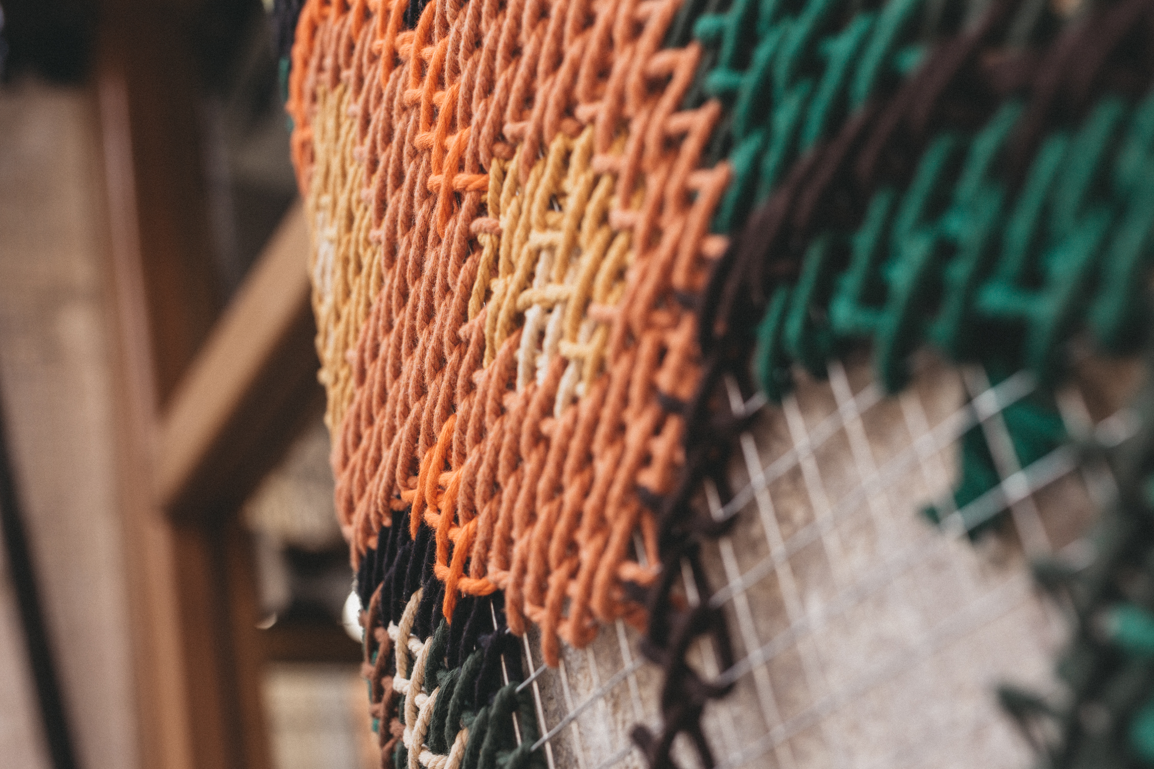 Anartxy — macro detail of orange embroidery stitch on metallic mesh