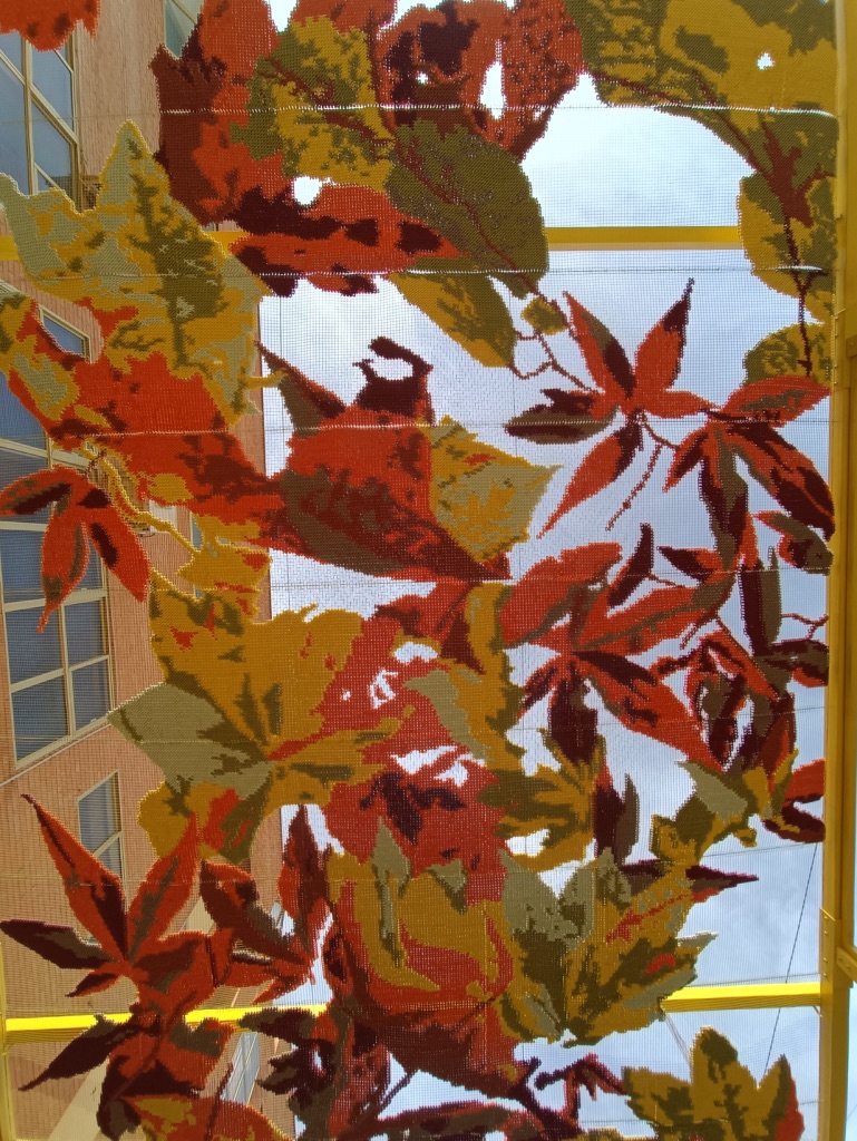 Katarsis — detail of embroidered autumn leaves on metallic mesh