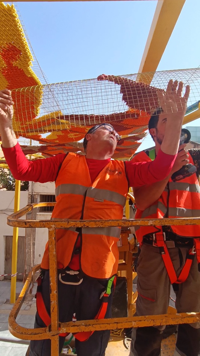 Katarsis — installation process, team placing embroidered panels on the shade structure